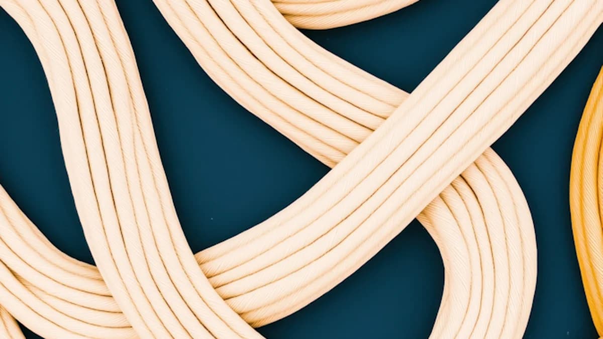 Cordas entrelaçadas em tons bege sobre fundo azul-petróleo, representando a mistura entre pessoal e profissional no WhatsApp