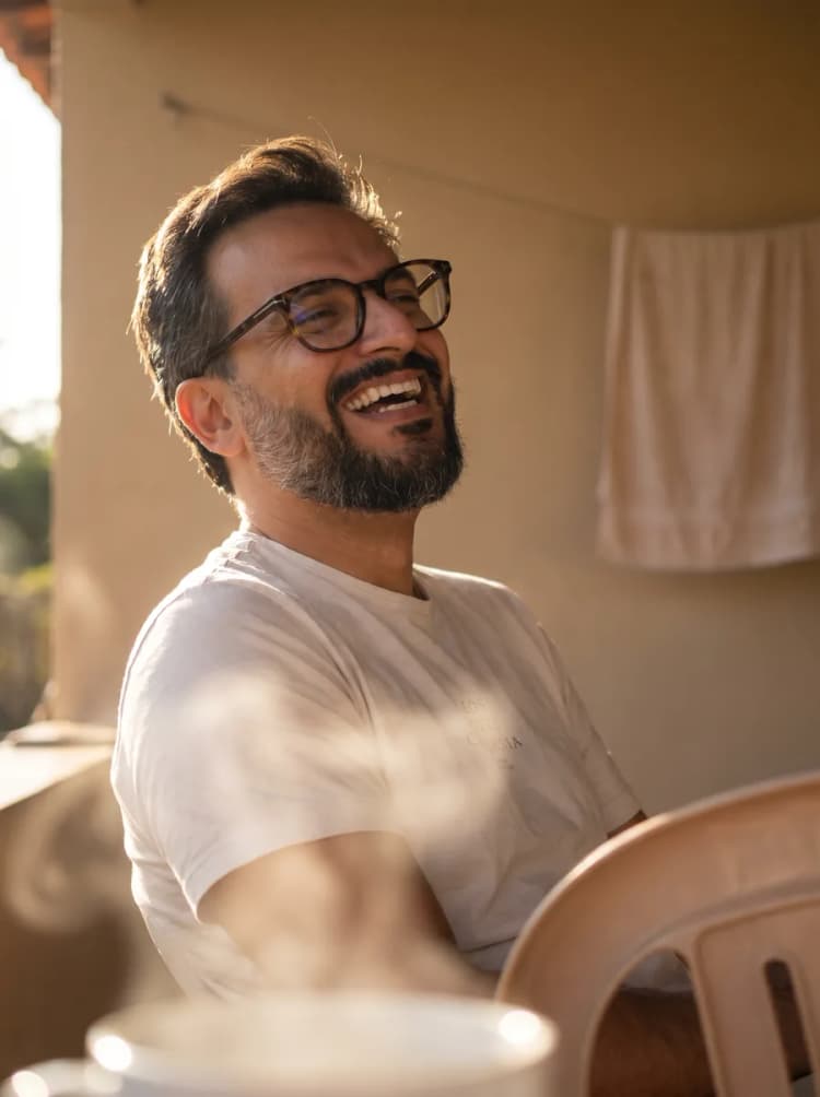Pedro Moura, fundador da Ekoa, rindo numa varanda ao fim da tarde